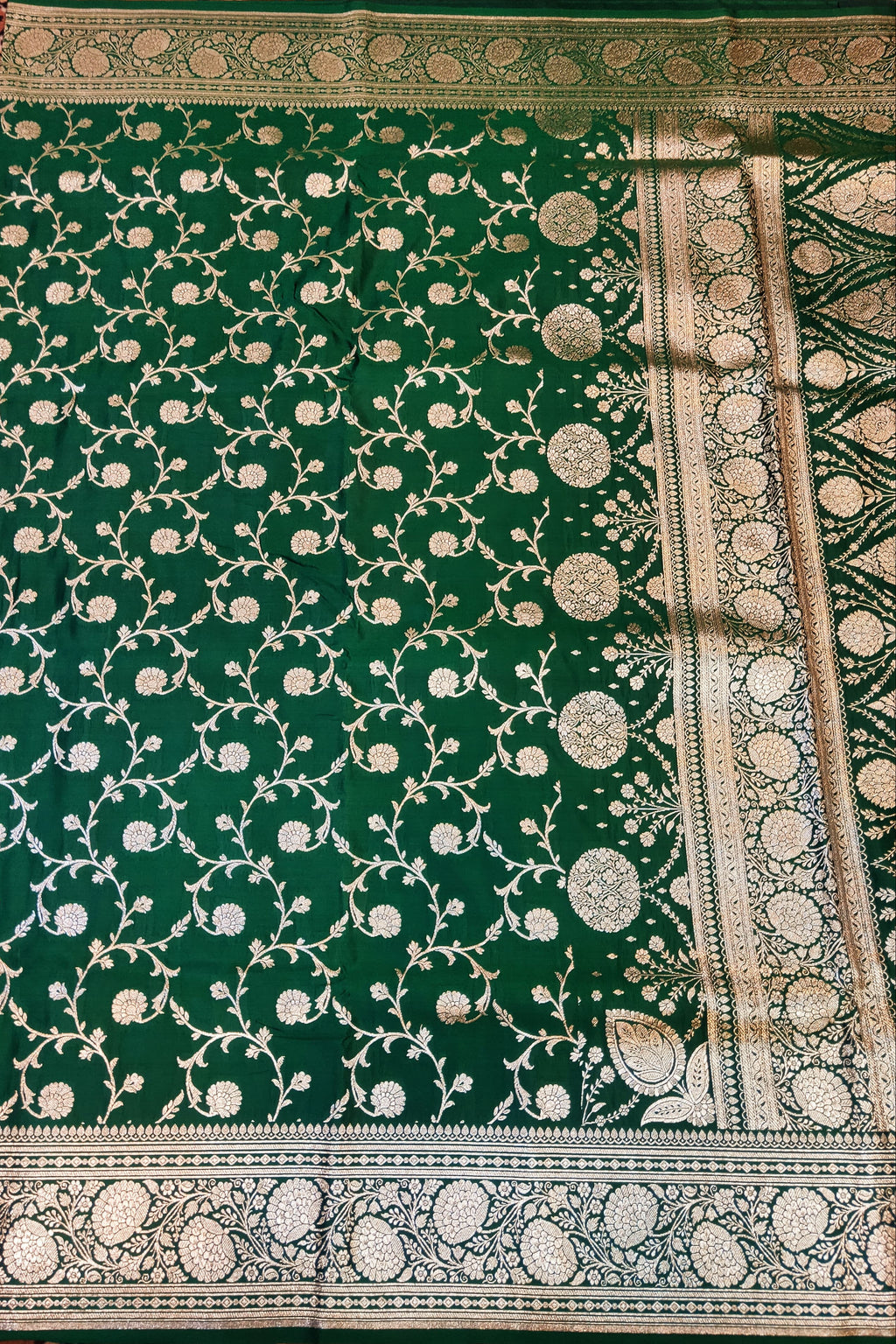 Green fabric with intricate white patterns on a patterned background