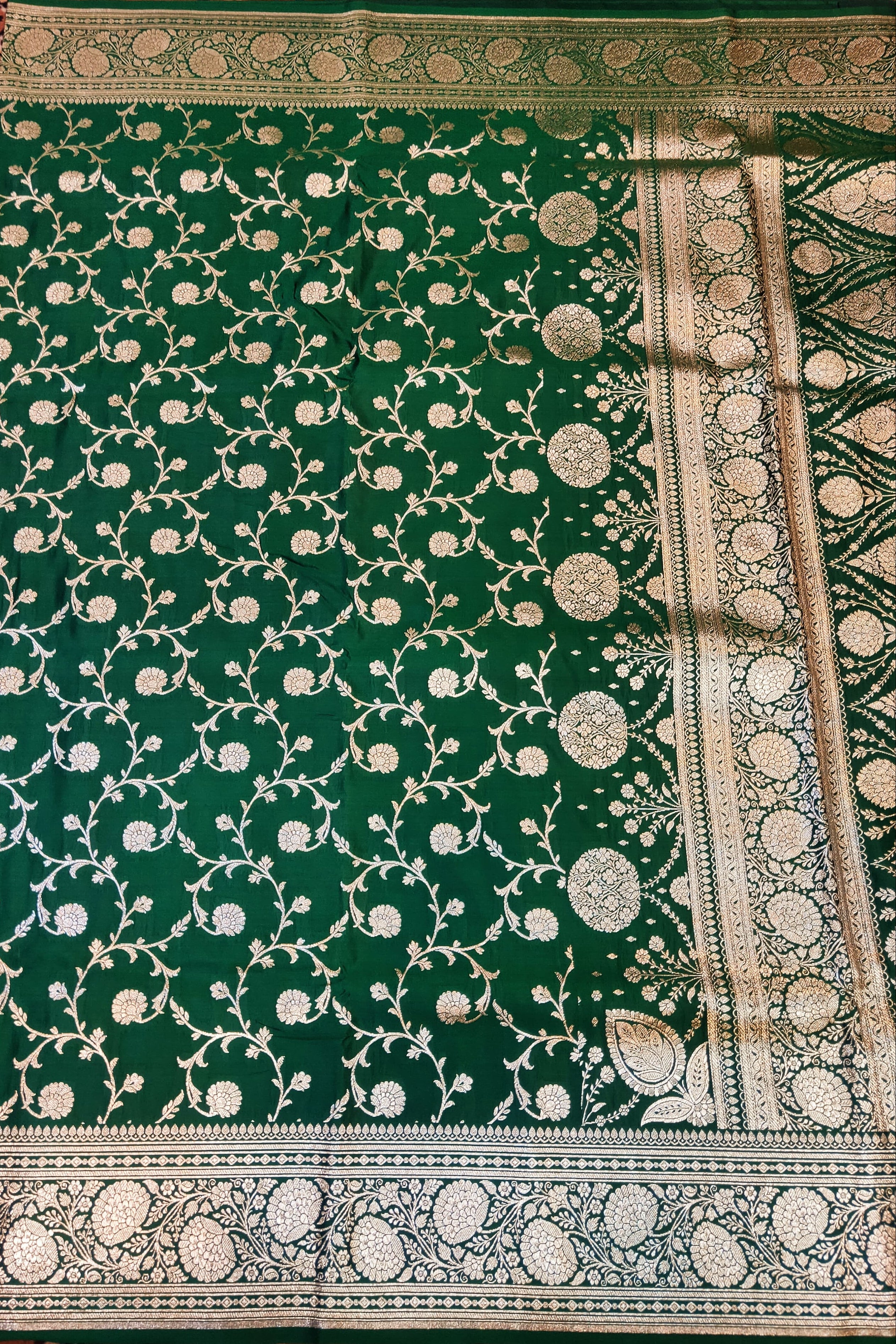 Green fabric with intricate white patterns on a patterned background