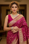 Woman in a pink saree with gold patterns indoors