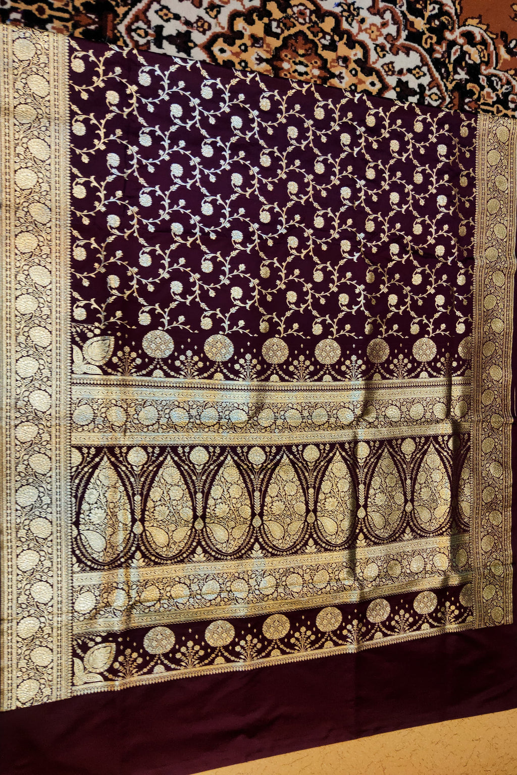 Decorative purple fabric with intricate gold patterns on a matching background