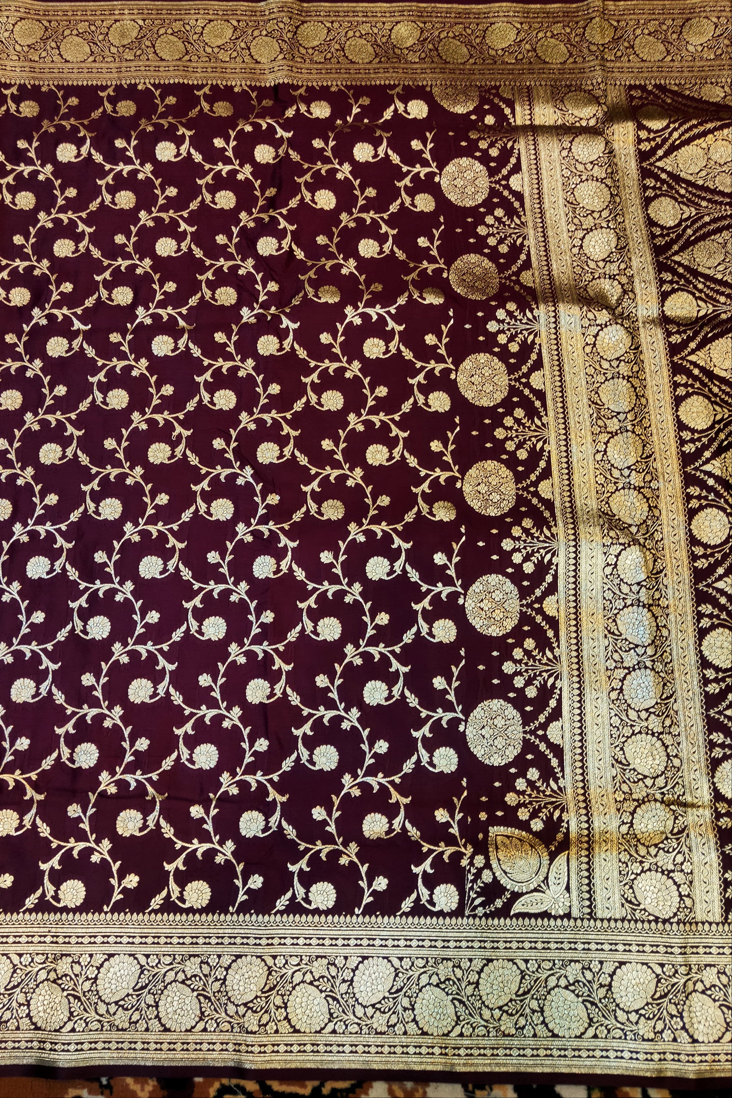 Purple fabric with intricate gold patterns on a textured surface