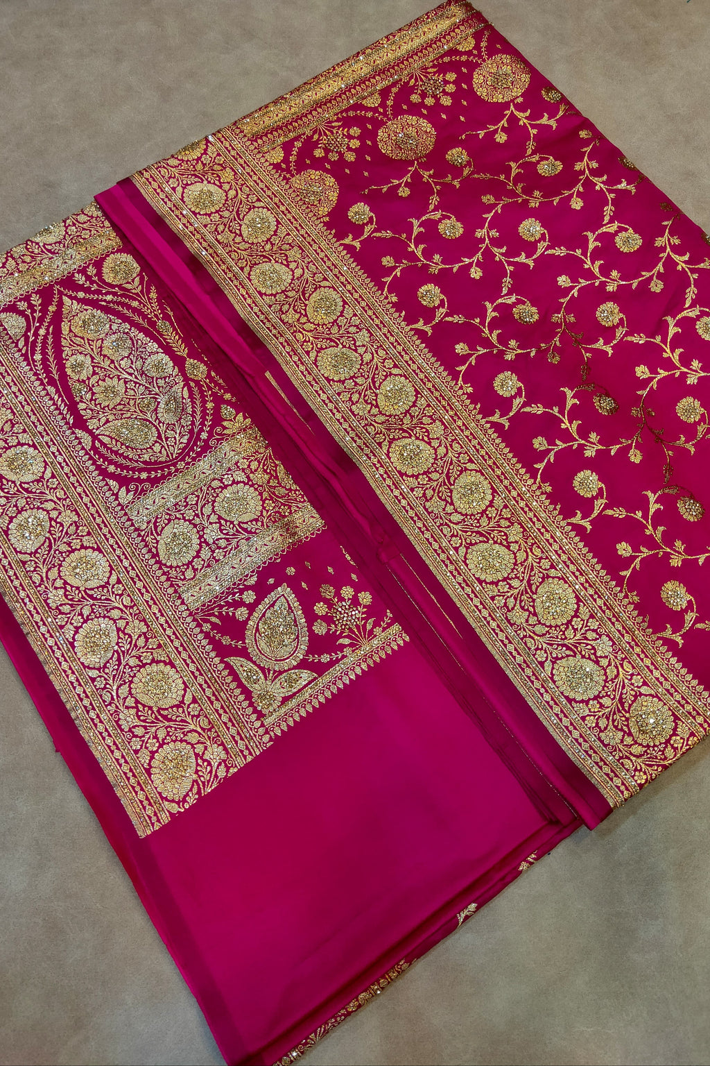 Pink saree with gold embroidery on a neutral background