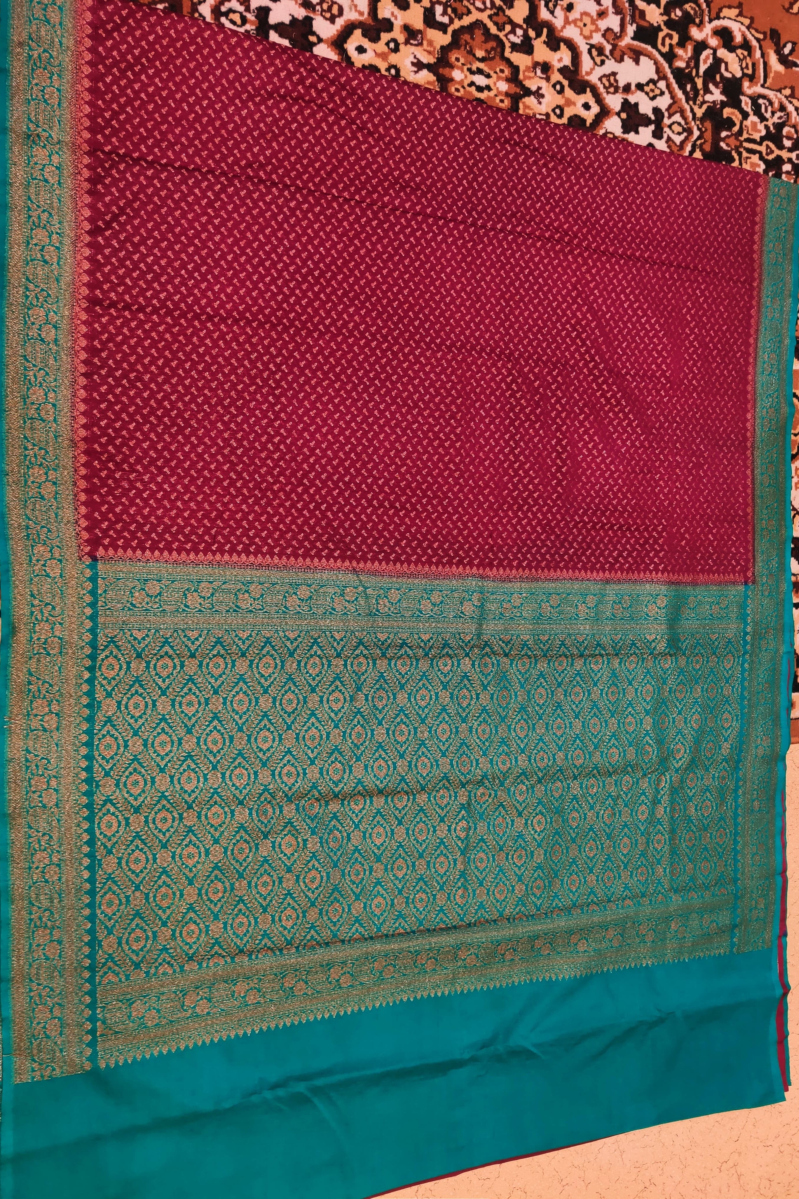 Maroon and teal saree with a patterned background