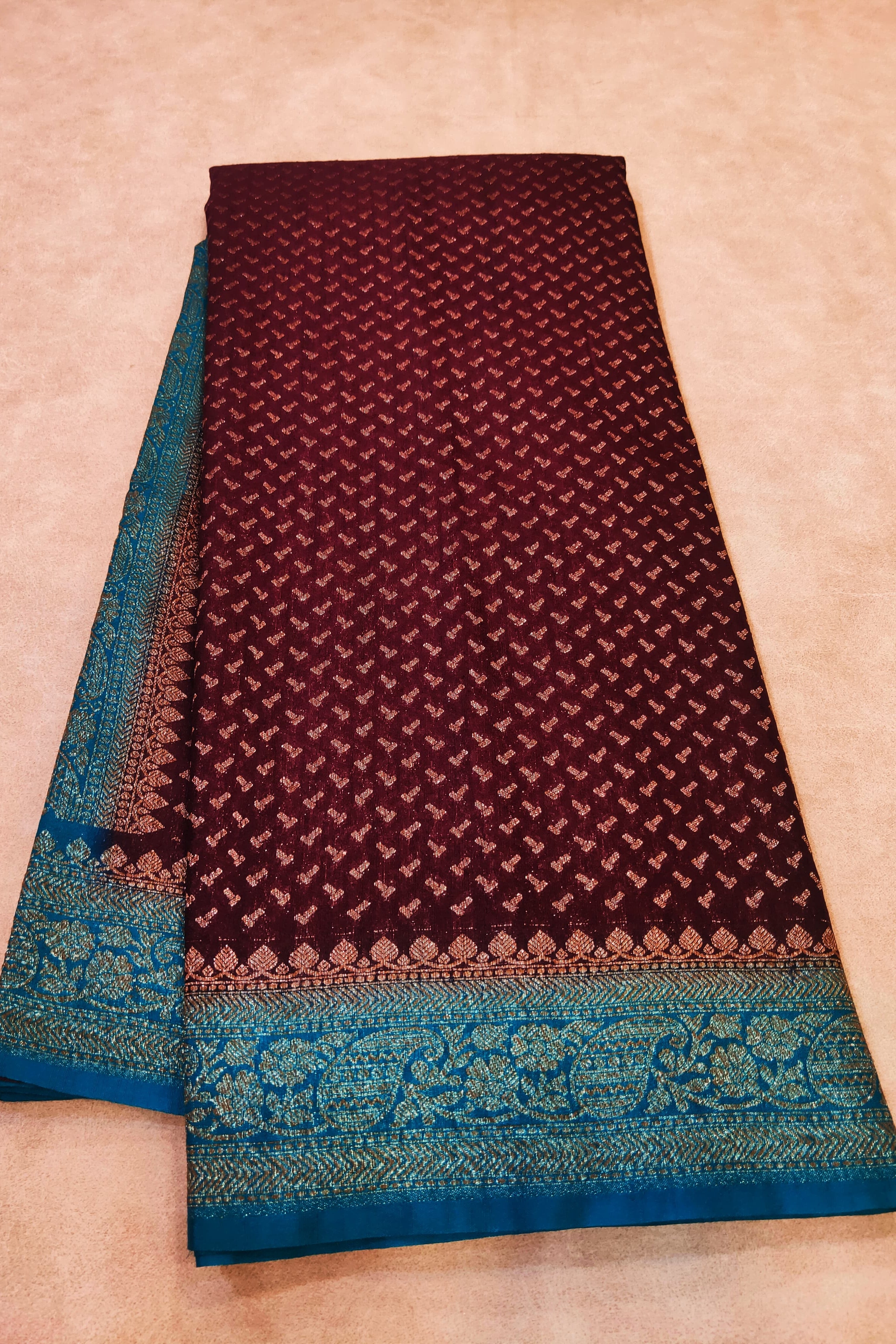 Maroon and blue patterned fabric on a beige background