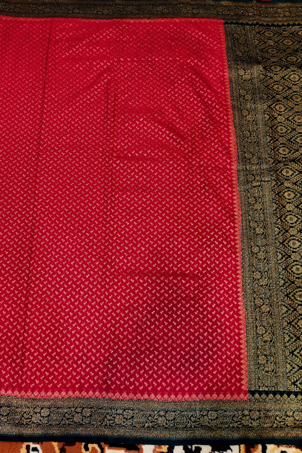 Red fabric with black border on a patterned background