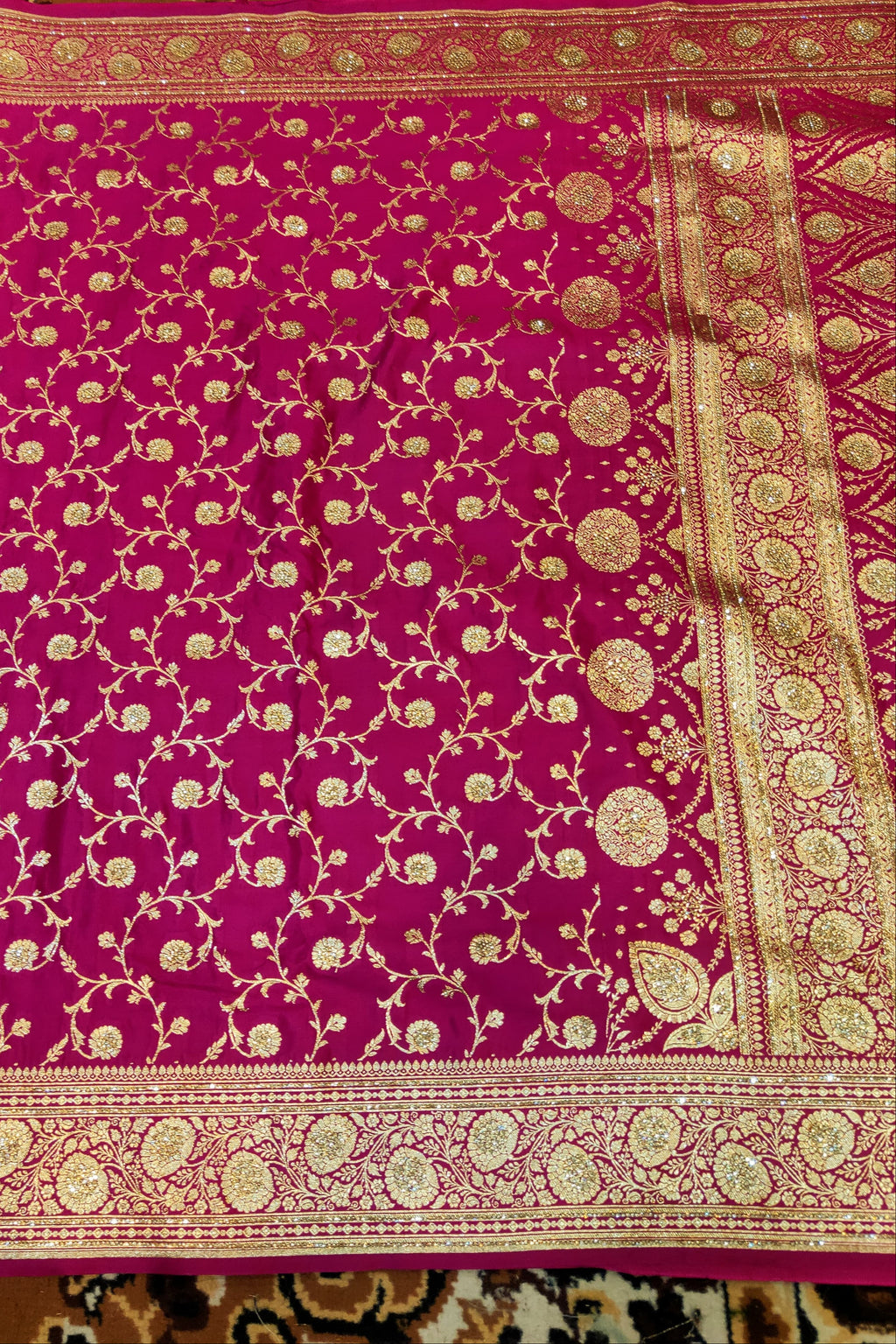 Pink fabric with gold intricate patterns on a patterned background