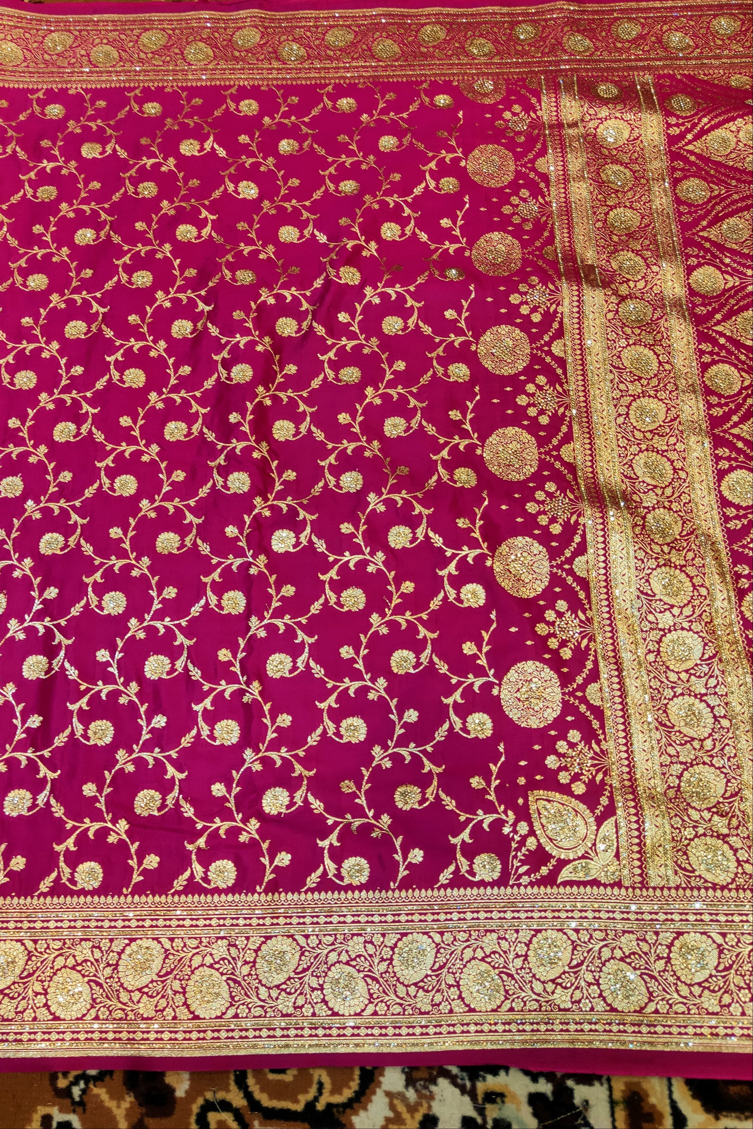 Pink fabric with gold intricate patterns on a patterned background