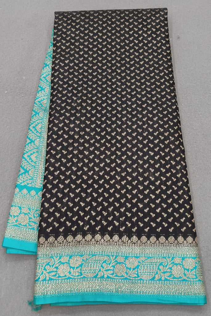 Black fabric with white pattern and turquoise border on a gray background