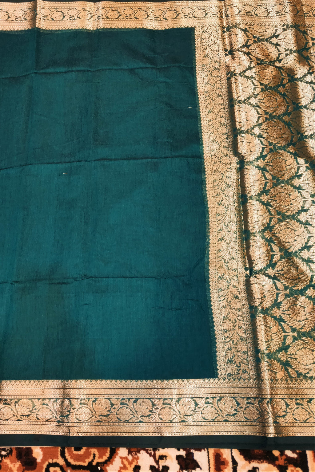 dark green fabric with gold border on a surface