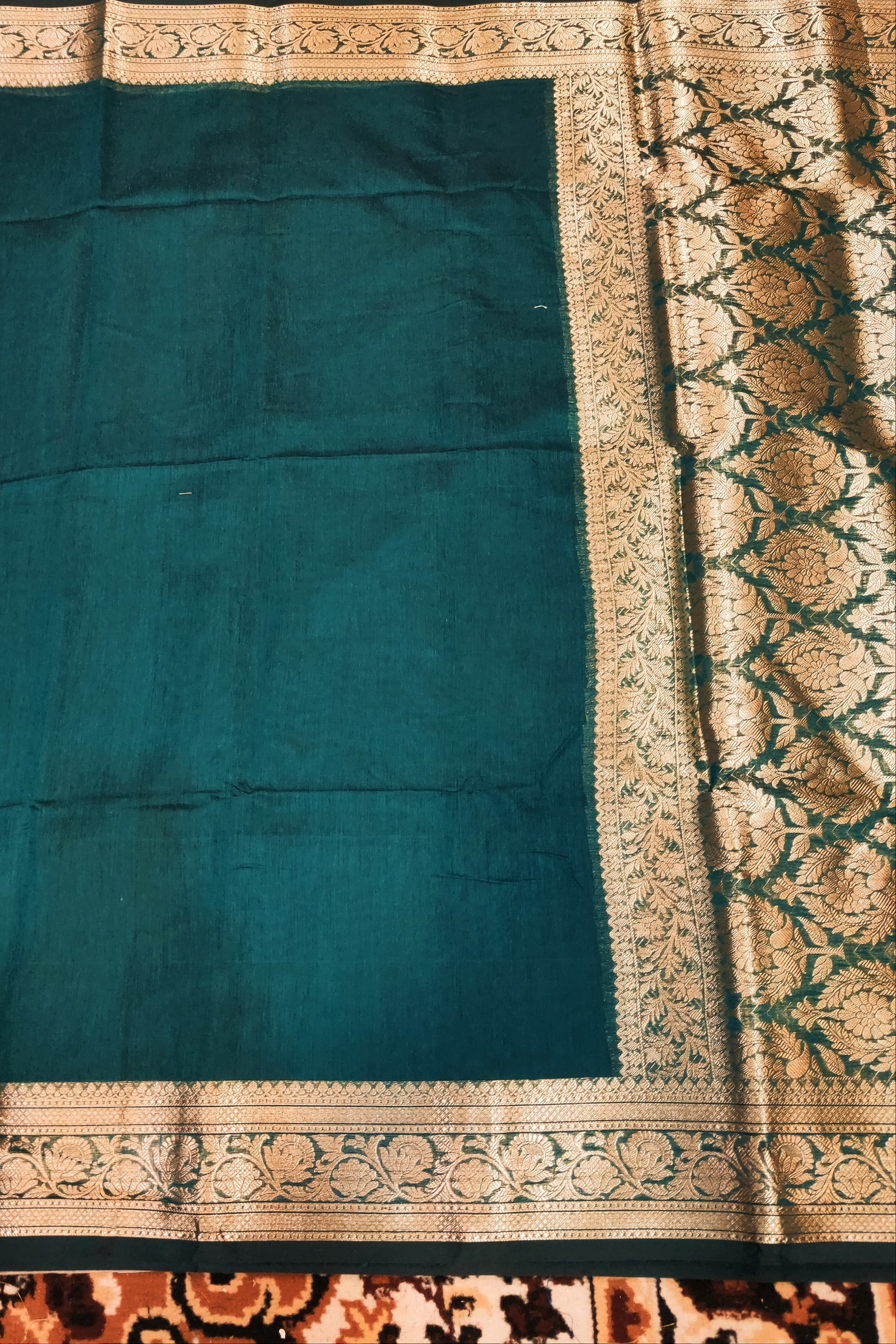 dark green fabric with gold border on a surface