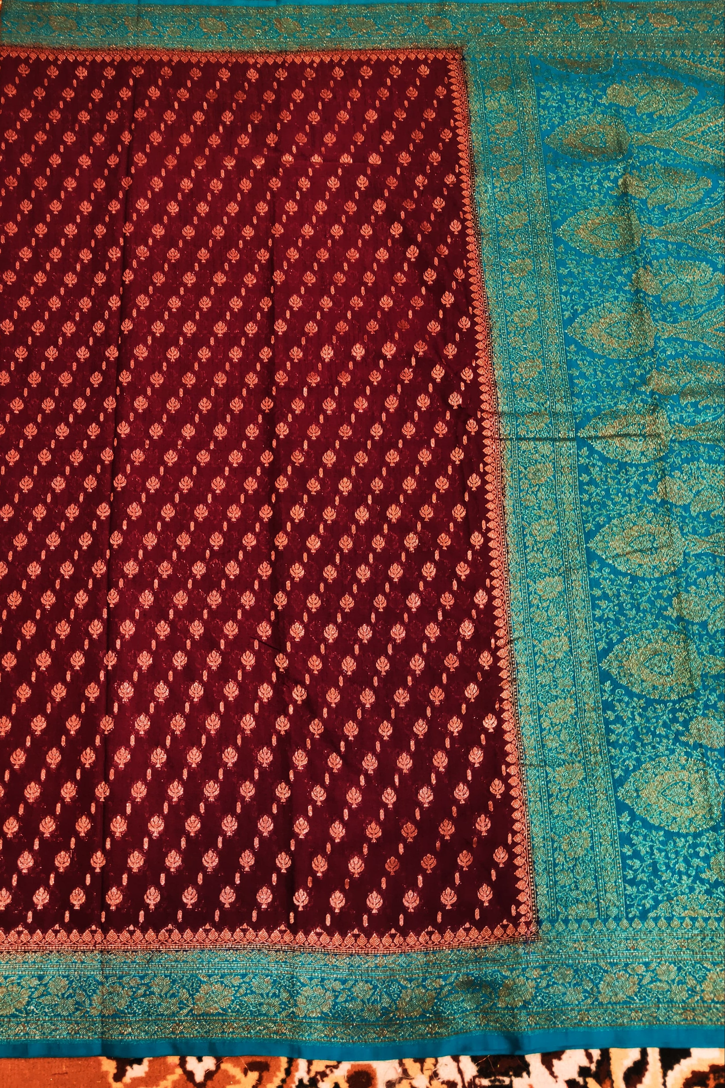 Traditional patterned fabric with a maroon and blue border on an intricate background