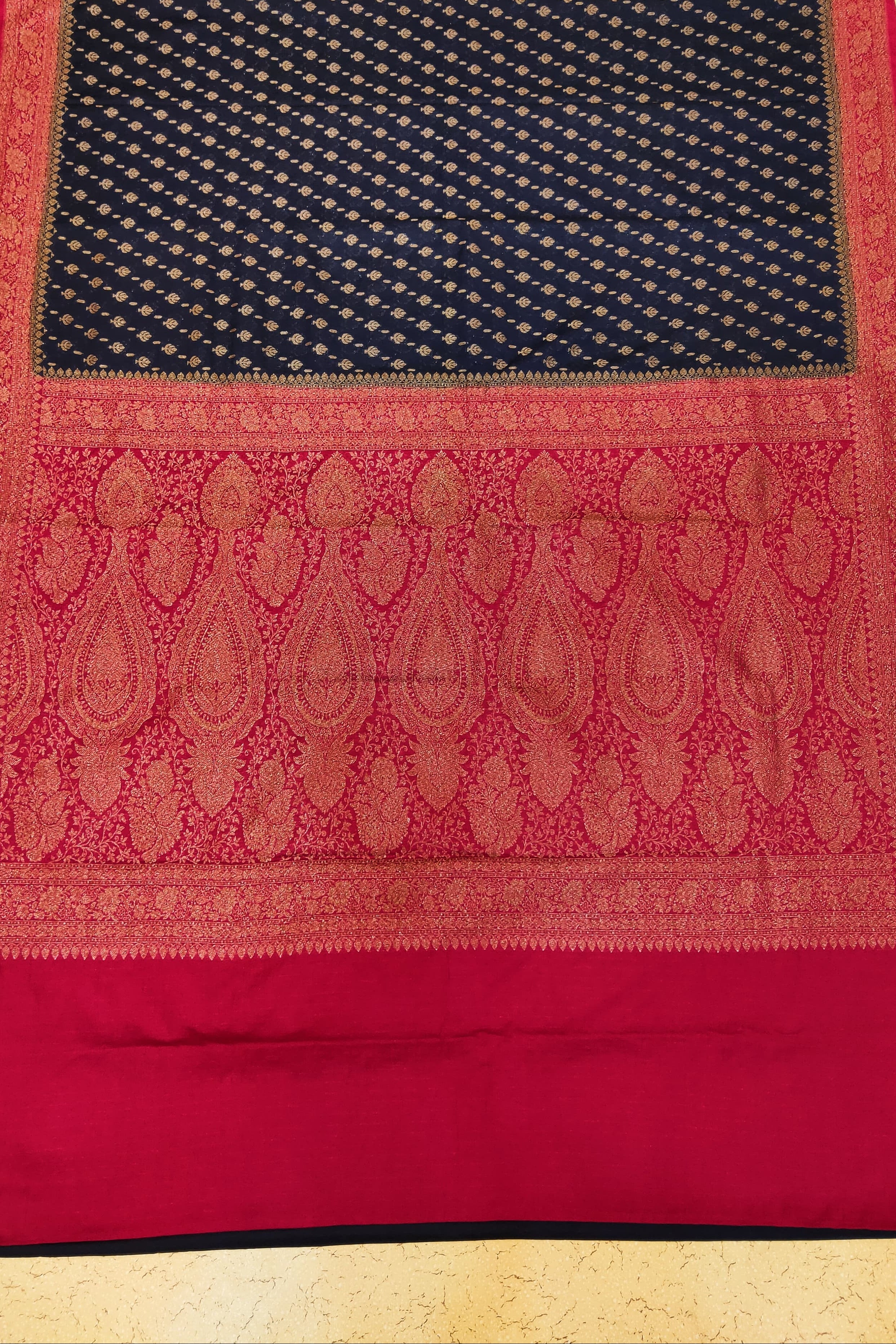 Traditional saree with black and red patterns on a gold background