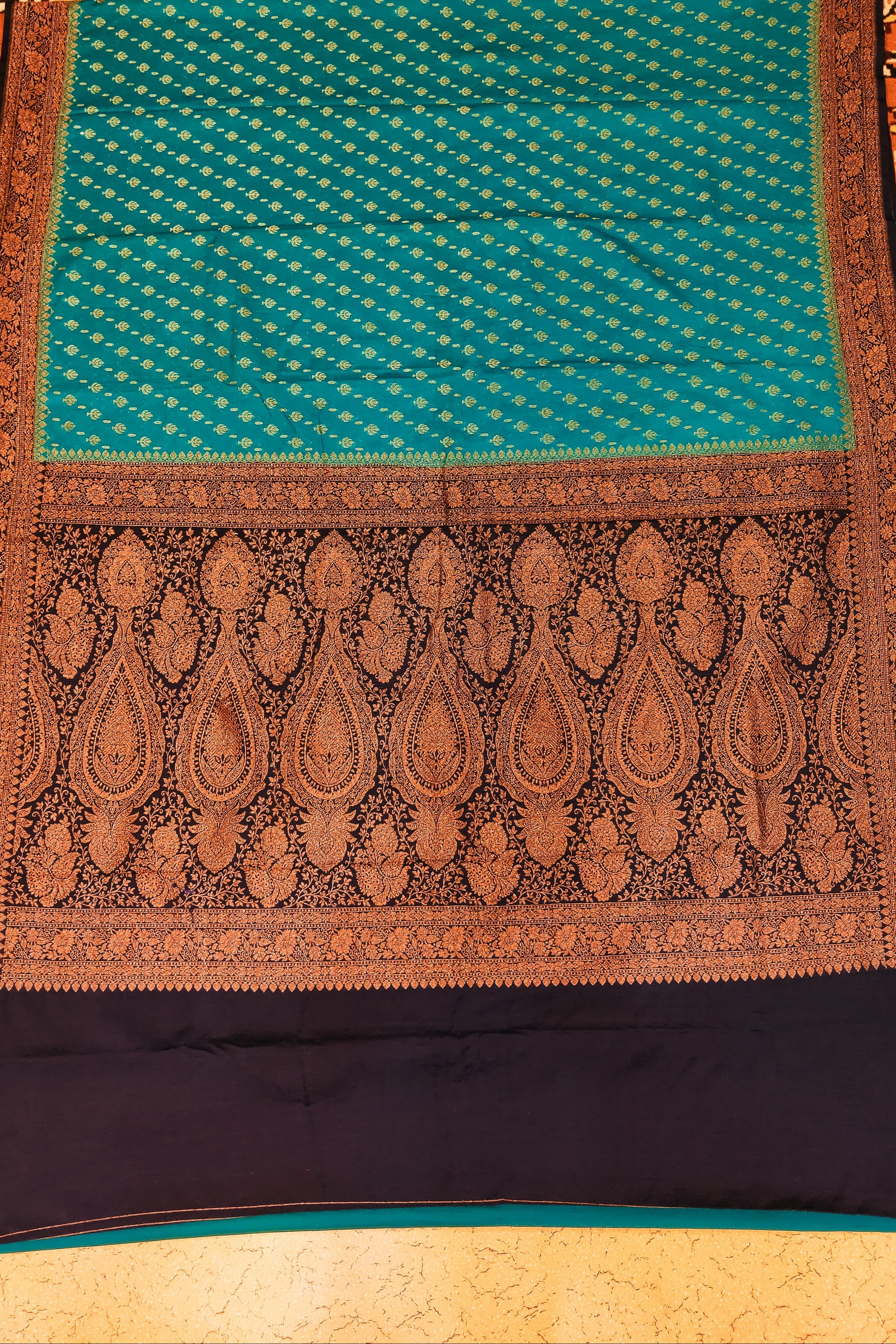 Traditional patterned fabric with a blue and brown design on a textured background