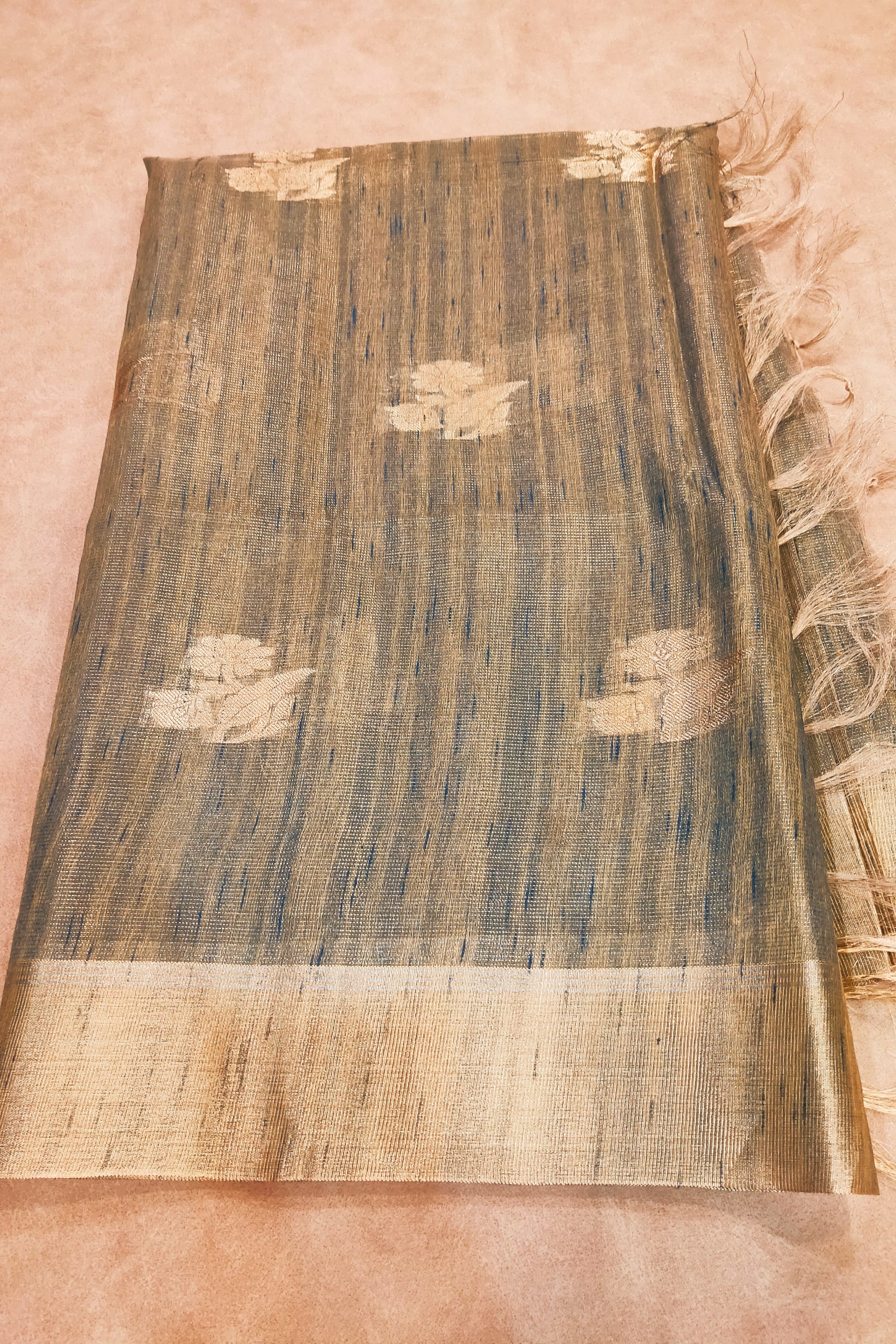 Textured fabric with gold and blue patterns on a pink background